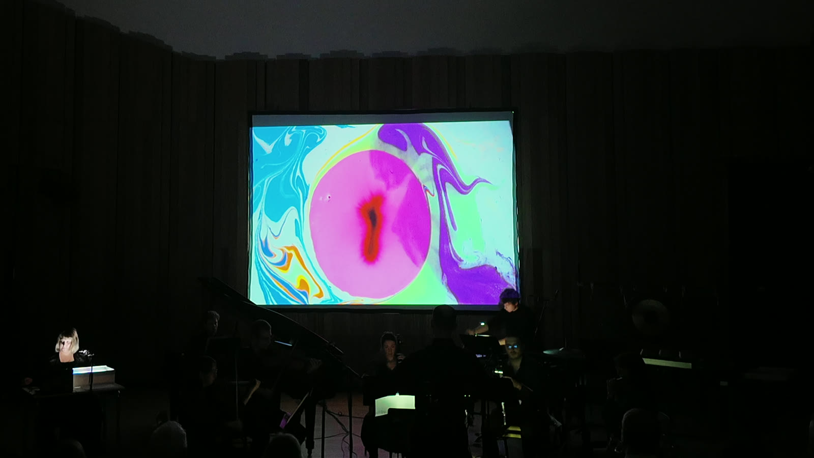 a magenta drop blooms inside the marbled field above the players